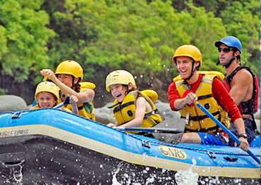 A family enjoying river rafting during their vacation