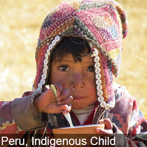 An indigenous child enjoys a meal in Peru